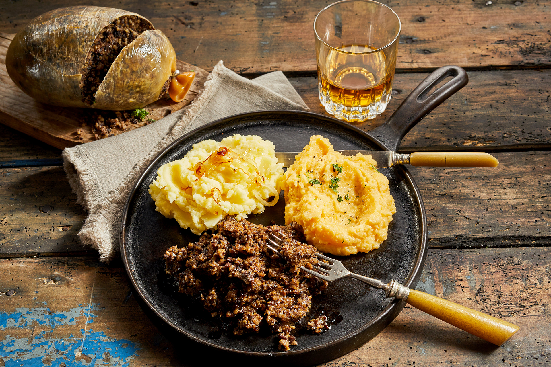 Rustic meal of haggis, neeps and tatties served with a tumbler of whisky to celebrate Robert Burns Supper in a high angle view Rustic meal of haggis, neeps and tatties served with a tumbler of whisky to celebrate Robert Burns Supper in a high angle view