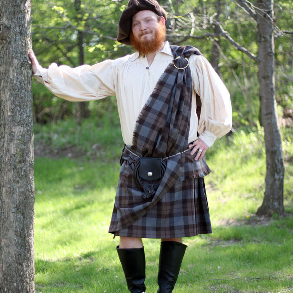 A man in a kilt leaning against a tree, showcasing the traditional attire mentioned in the kilt buyer guide. A man in a kilt leaning against a tree, showcasing the traditional attire mentioned in the kilt buyer guide.