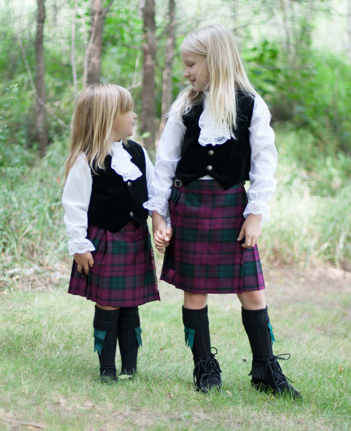Two little girls wearing kilts they received as Christmas gifts