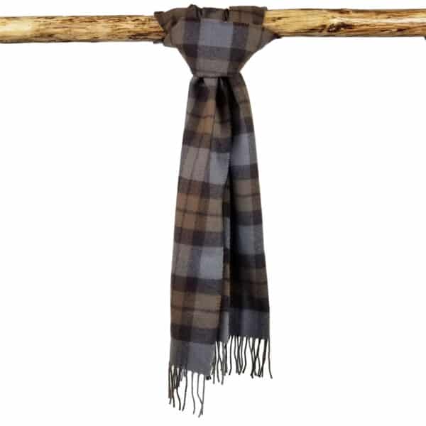 An Tartan Scarf - OUTLANDER Lambswool in brown and gray plaid with fringed ends is draped over a wooden rod.