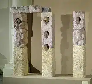Three Celtic stone sculptures on display in a museum.