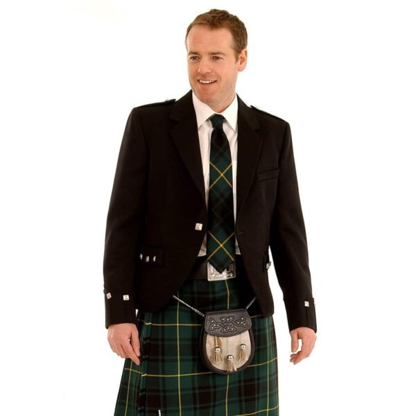 A man in a kilt and Rental Argyle Jacket is smiling.