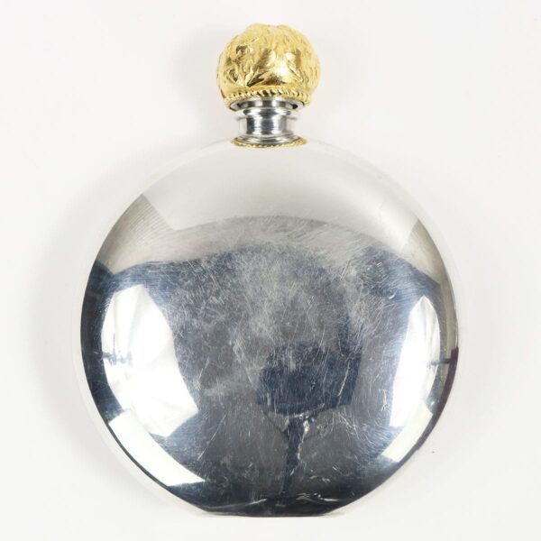 An Anderson Clan Crest Flask - 24ct Gold Accents, featuring silver and gold accents, resting gracefully on a pristine white surface.