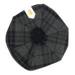 A Night Watch Tartan Tam hat with a pom pom.