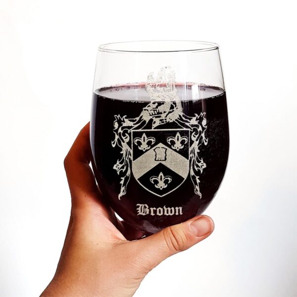 A person holding an Irish Coat of Arms stemless wine glass with a family crest on it.