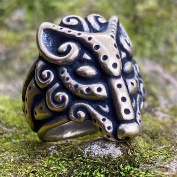 A Celtic Wolf Ring with a wolf head on top of moss.
