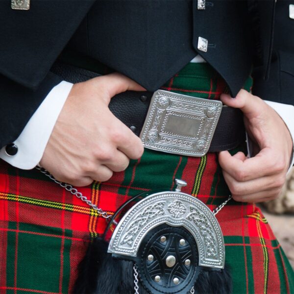 A man wearing a kilt accessorized with Celtic Knot Kilt Belt Buckles.