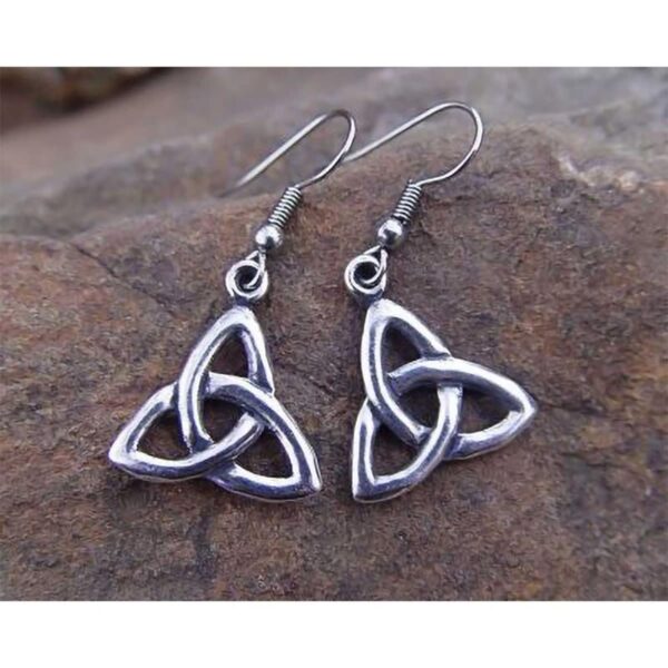 A stunning pair of Triquetra Earrings beautifully displayed on a rock.