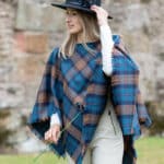 A woman wearing a Light Weight 11oz Premium Wool Tartan Poncho.