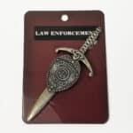 A Law Enforcement Kilt Pin shaped like a sword with intricate designs, displayed on a dark background with the text "law enforcement" above.