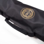 Deluxe black fabric carrying case with a handle, featuring a golden emblem with "Pacific Trillium Outdoors" and an illustration of mountains and trees on the side, named the Deluxe Kilt Carry Roll.