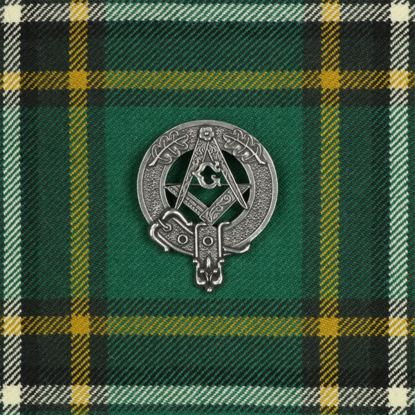 A green and yellow Masonic Cap Badge/Brooch on a green tartan.