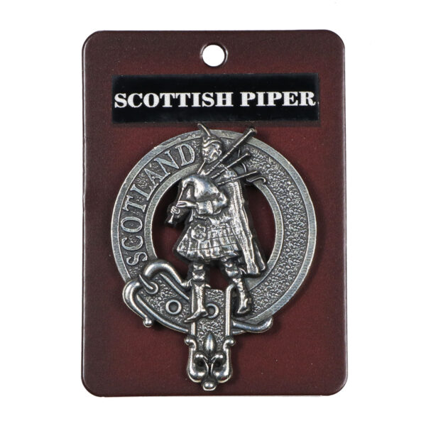 A Scottish Piper Cap Badge/Brooch on a card.