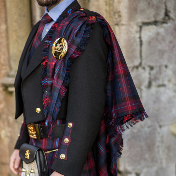 A man wearing a kilt and a Welsh Tartan Medium Weight Premium Wool Fly Plaid.