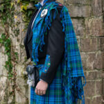 A man donning a Welsh Tartan Medium Weight Premium Wool Fly Plaid kilt.