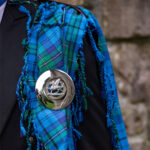 A man is wearing a Welsh Tartan Medium Weight Premium Wool Fly Plaid.
