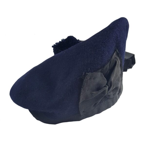 The Felted Wool Balmoral is described as a blue beret with a black bow on it.