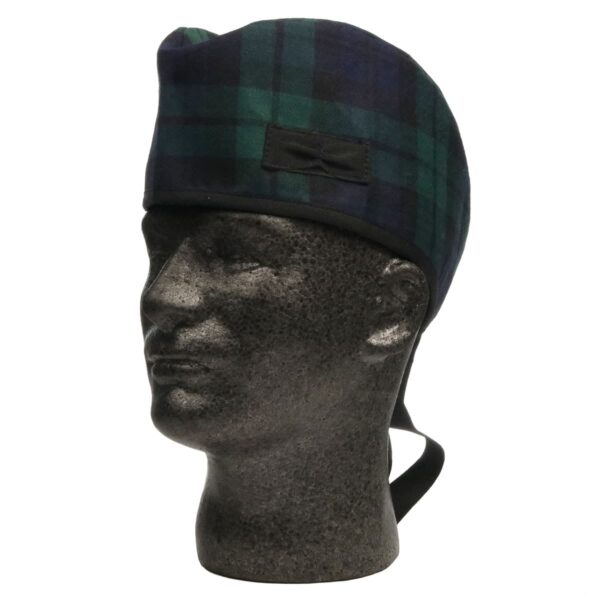 A mannequin wearing a green and black tartan hat.