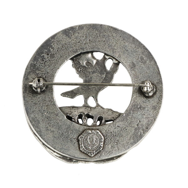 A silver brooch with a bird on it, featuring an Irish Family Crest Cap Badge/Brooch.