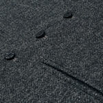 A close up image of a grey wool coat with buttons and a Tweed 5 Button Vest.