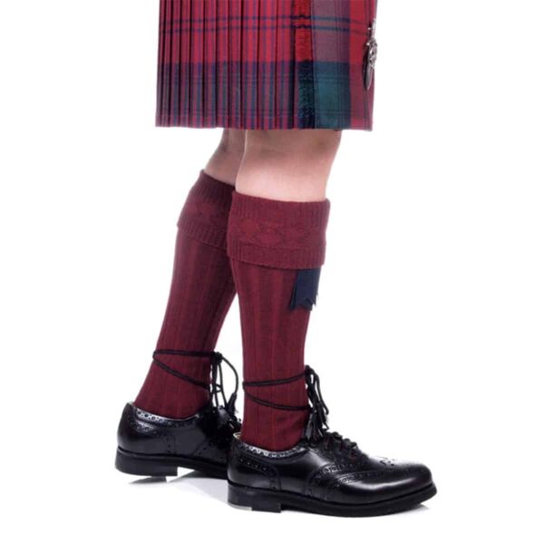 A man wearing a plaid kilt paired with Quality Wool Blend Kilt Hose.