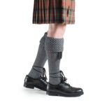A Piper Kilt Hose wearing a kilt and black hose (Special Order).