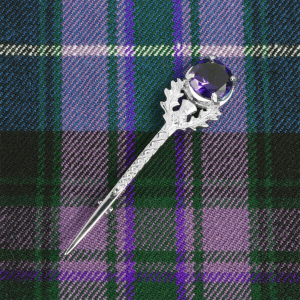 A Scottish tartan lapel pin with a Large Gem Amethyst Thistle Kilt Pin.