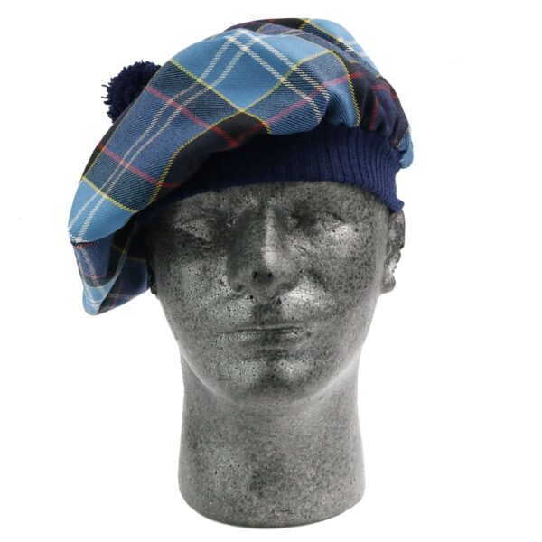 A mannequin wearing a blue tartan beret, complemented by a U.S. Marine Corps Premium Light Weight Wool Tam, was observed in the display window.