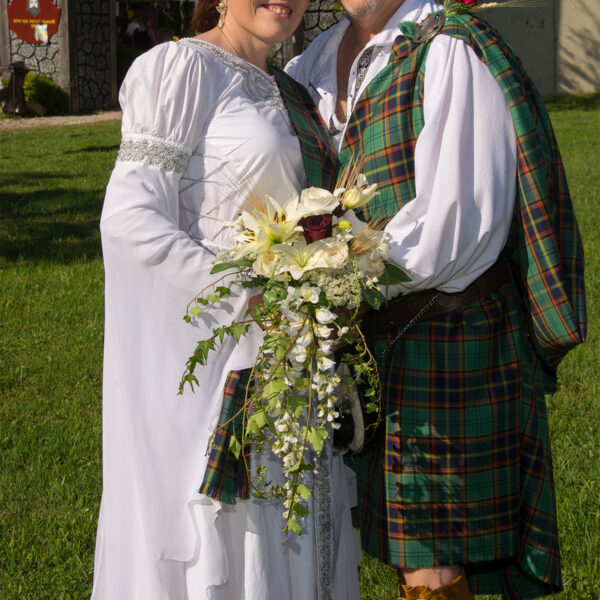 A man and woman, decked out in the Heavy Weight 16oz Premium Wool Ancient Kilts, strike a pose for a picture.