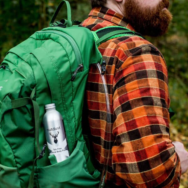 A bearded man with a backpack, carrying a water bottle and covered in Nutdust - Laddie.