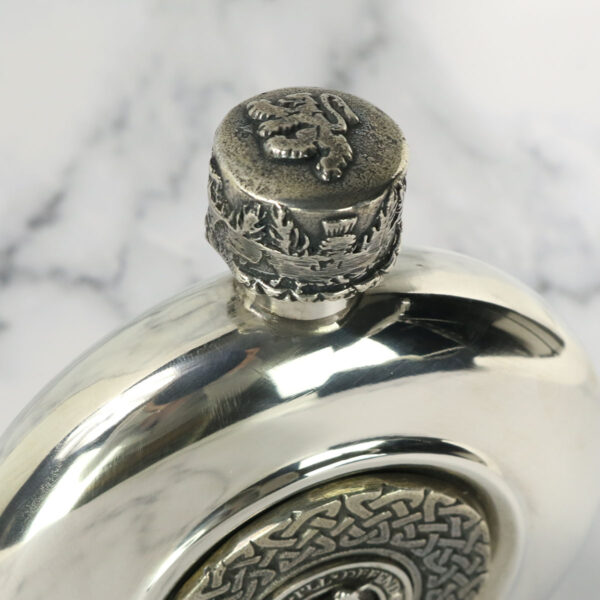 A Clan Crest Antiqued Pewter Flask with a clan crest design on it.
