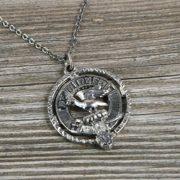 A silver Clan Crest Necklace with an eagle on it.