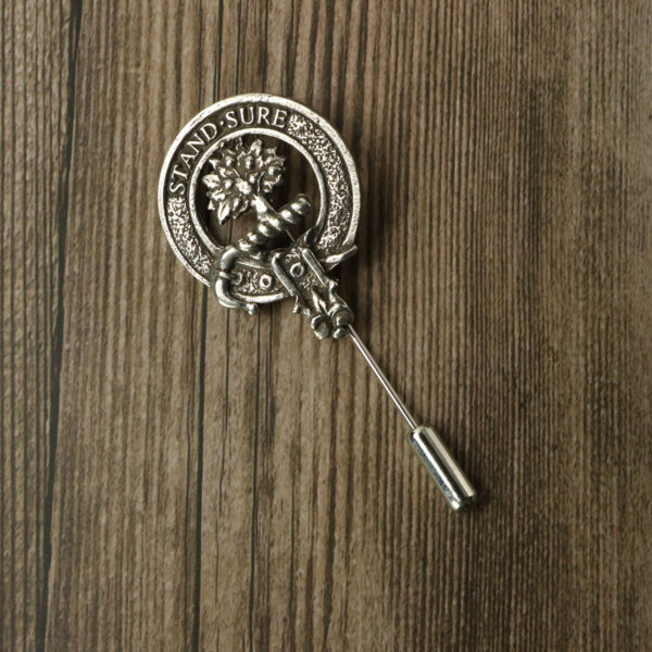 A Gaelic Themes Clan Crest lapel pin placed on a wooden table.
