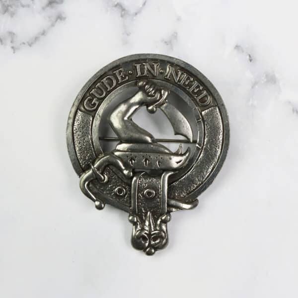 A metal badge with a scottish crest on it.