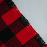 A close up of a red and black Homespun Tartan Blanket/Throw.