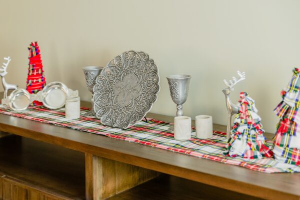 A table adorned with Reversible Tartan Table Runner - Homespun Wool Blend, showcasing vibrant Christmas decorations.