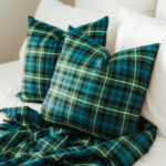 Two homespun tartan blanket/throws on a bed.
