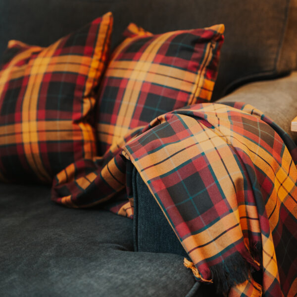 A Homespun Tartan Blanket/Throw on a couch.