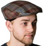 A man wearing an OUTLANDER Golf Cap Authentic Premium Wool Tartan hat.