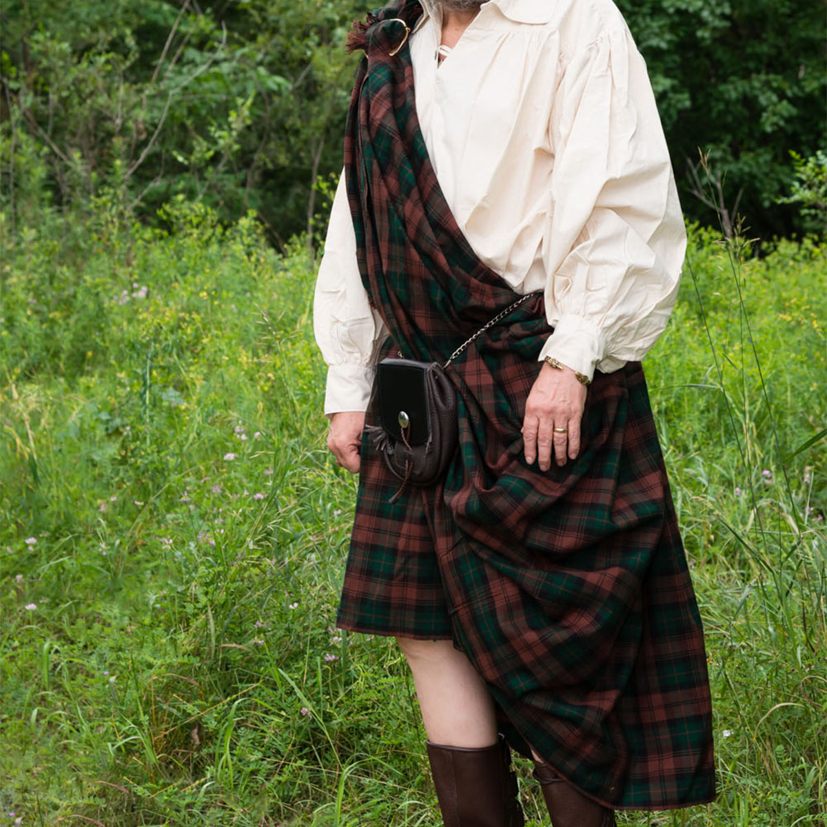 A man in a Great Kilt - Poly/Viscose Wool-Free standing in a field.