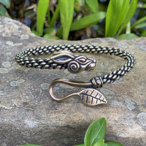 A braided bracelet with a leaf on it.