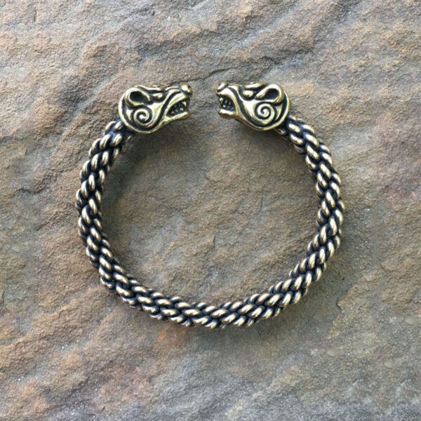 A Celtic Bear Torc Bracelet with two viking heads on it.