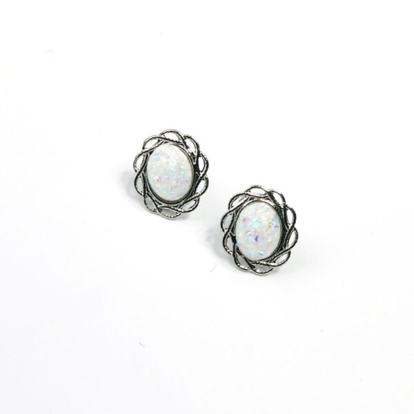 A pair of Opal Knot Stud Earrings on a white surface.