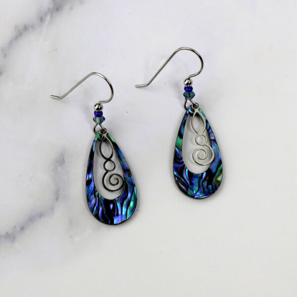 A pair of Celtic Spiral Paua Shell earrings with silver swirls on them.