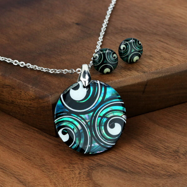 A Triskelion spiral necklace and Triskelion Spiral Paua Shell Earrings set with a swirling design.
