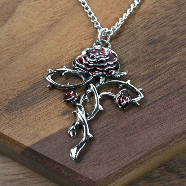 An Amethyst Celtic Knot Necklace with a red rose on it.