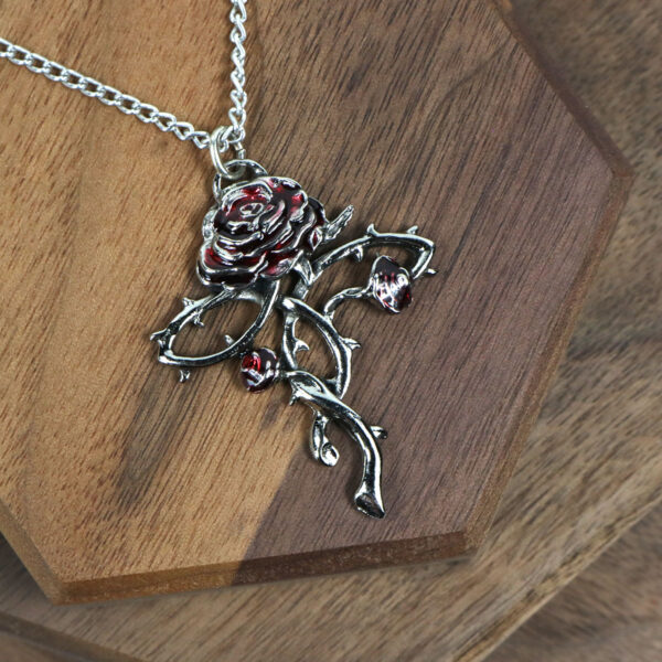 An Amethyst Celtic Knot Necklace adorned with a red rose pendant.