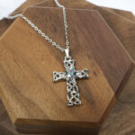 An Amethyst Celtic Knot Necklace adorned with a blue crystal.