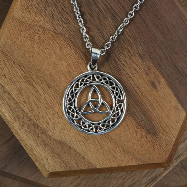 An Amethyst Celtic Knot necklace on a wooden table, showcasing its intricate design.