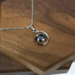 An Amethyst Celtic Knot Necklace with a silver pendant featuring an amethyst stone.